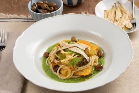 Spaghetti with zucchini cream, yellow cherry tomatoes, and marinated anchovies