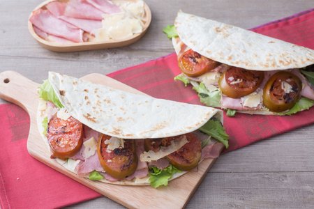 Flatbread with ham, pecorino cheese, and tomatoes