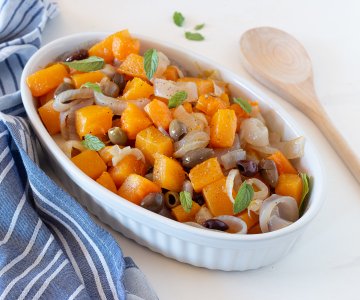 Pumpkin in the pan with onions and olives