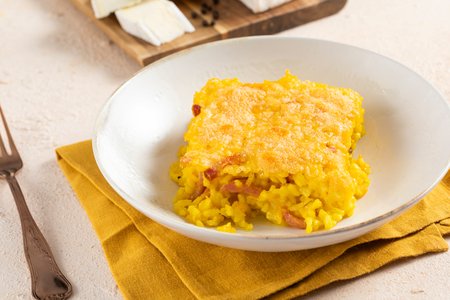 Baked saffron rice with speck and brie