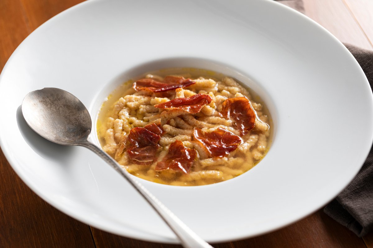 Passatelli with ham in meat broth