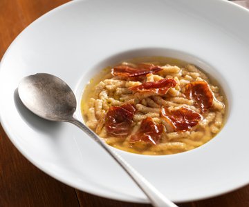 Passatelli with ham in meat broth