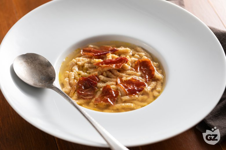 Passatelli with ham in meat broth