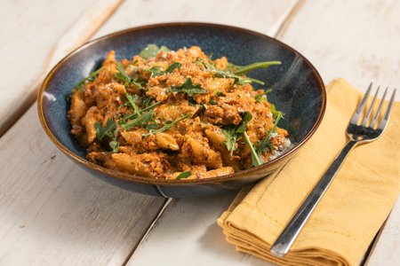 Mezze penne with red pesto and arugula